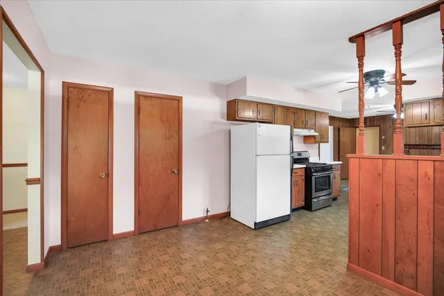a view of kitchen with refrigerator cabinets and a window