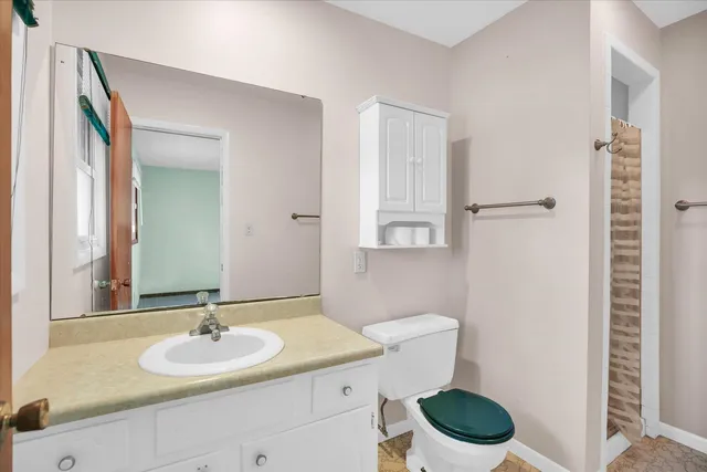 a bathroom with a toilet sink and mirror