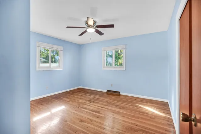 a view of empty room with window and ceiling fan