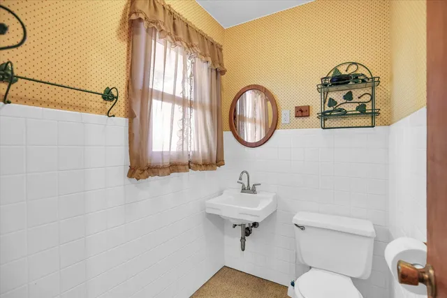 a bathroom with a toilet sink and mirror