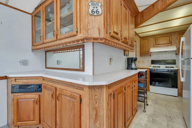 a kitchen with stainless steel appliances granite countertop a refrigerator and a stove top oven