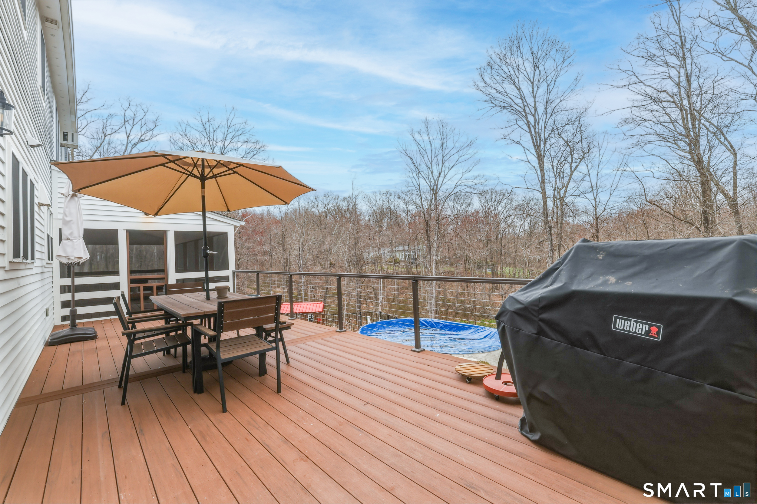 51 Sugar Loaf Road Guilford, CT 06437 - Photo 29 of 40 a view of a roof deck with table and chairs under an umbrella with wooden floor