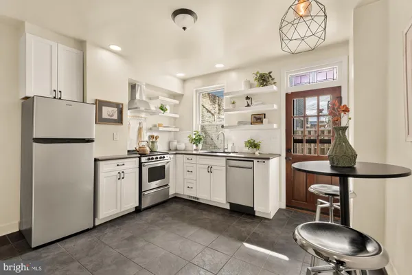 a kitchen with white cabinets and white appliances
