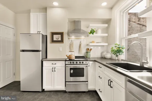 a kitchen with white cabinets and white appliances