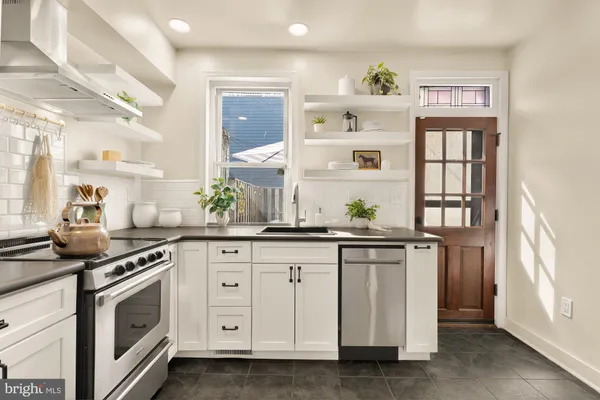 a kitchen with granite countertop white cabinets and white appliances