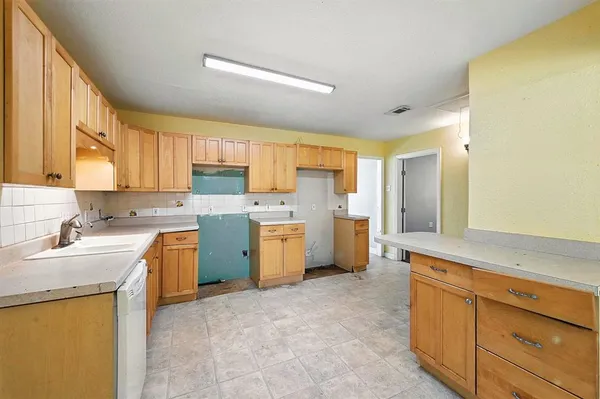 a kitchen with a sink stove top oven and refrigerator