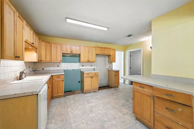a kitchen with a sink stove top oven and refrigerator