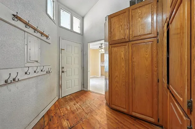 a view of a refrigerator in kitchen and white cabinets
