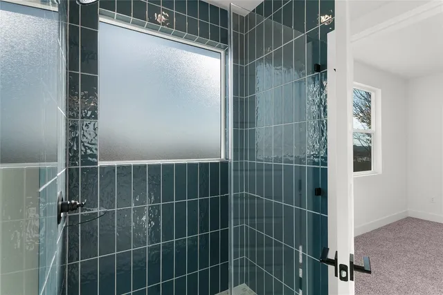 an empty room with a bathroom and a window