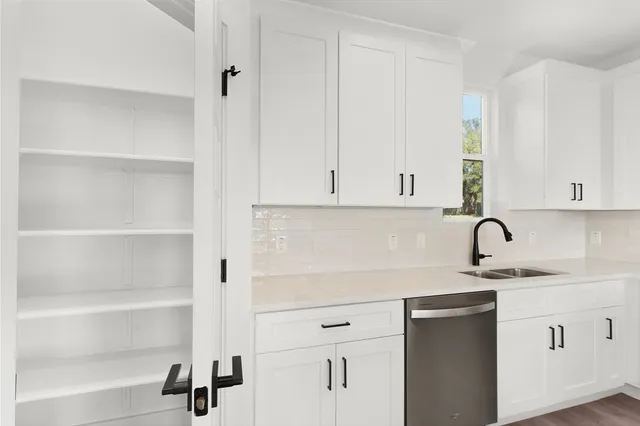 an empty room with wooden floor chandelier fan and windows