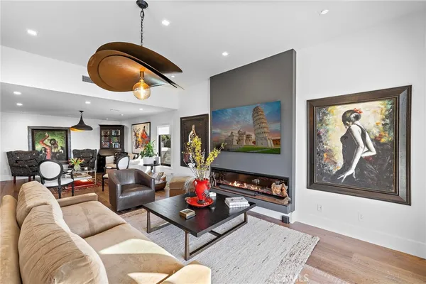 a living room with furniture piano and wall paintings