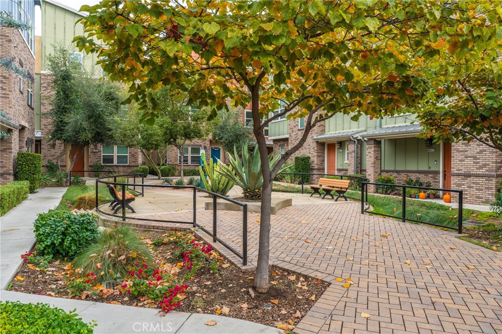 4956 Arrow Highway, Unit G Montclair, CA 91763 - Photo 4 of 32 a view of a garden with a bench and trees