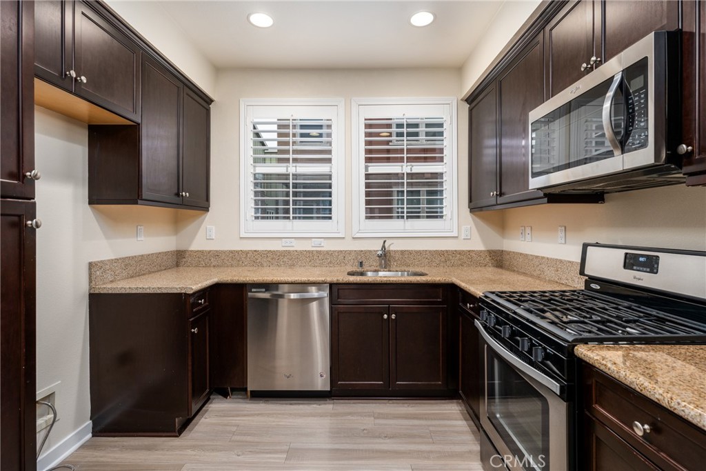 4956 Arrow Highway, Unit G Montclair, CA 91763 - Photo 8 of 32 a kitchen with stainless steel appliances granite countertop a stove and a sink