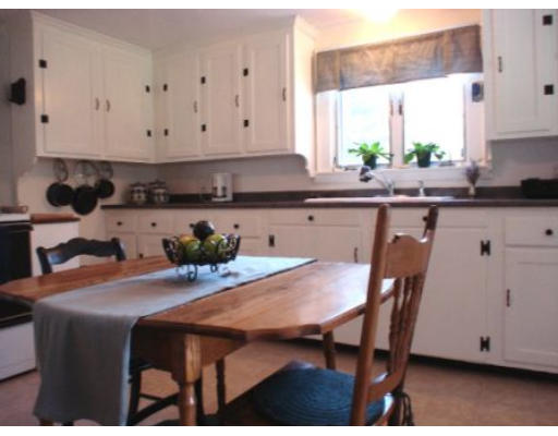 105 Spring Street Lexington, MA 02421 - Photo 6 of 18 a kitchen with stainless steel appliances granite countertop a table chairs sink and cabinets