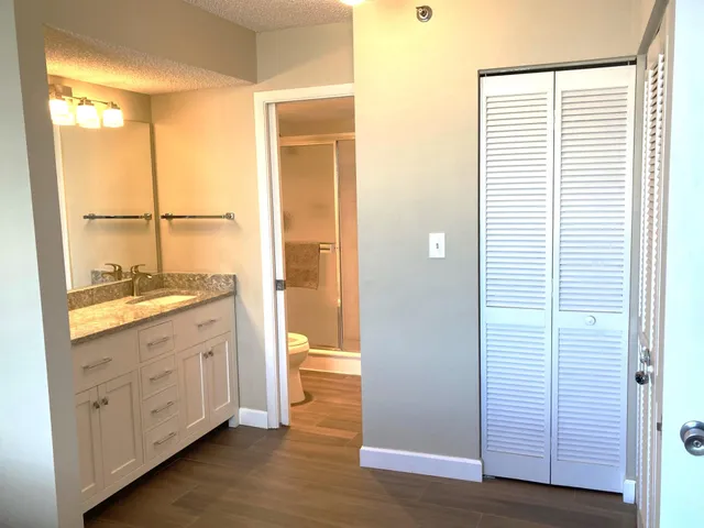 a bathroom with a granite countertop sink and a mirror