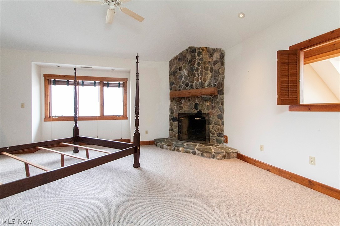 1871 Mattingly Road Hinckley, OH 44233 - Photo 27 of 50 Unfurnished bedroom featuring vaulted ceiling, a fireplace, ceiling fan, and carpet flooring