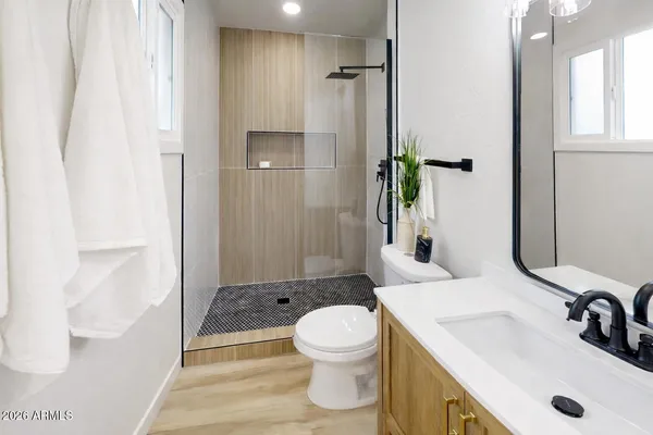 a bathroom with a sink a toilet and shower