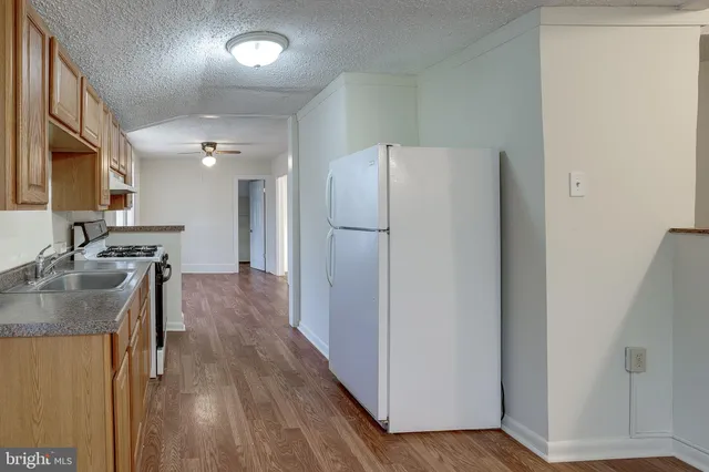 a kitchen with a refrigerator a sink and a stove top oven