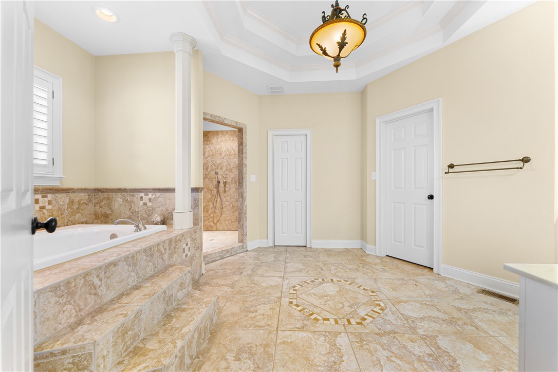 109 Limelight Drive Anderson, SC 29621 - Photo 8 of 34 This spacious primary bathroom features a luxurious soaking tub, a separate shower, and elegant tile flooring.