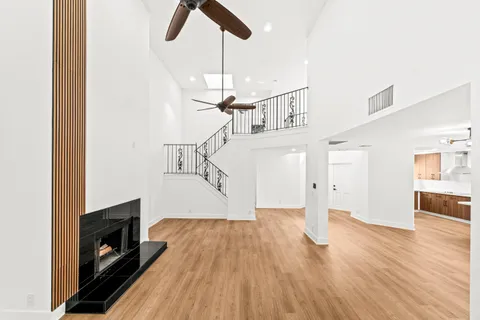 a view of empty room with wooden floor and fireplace