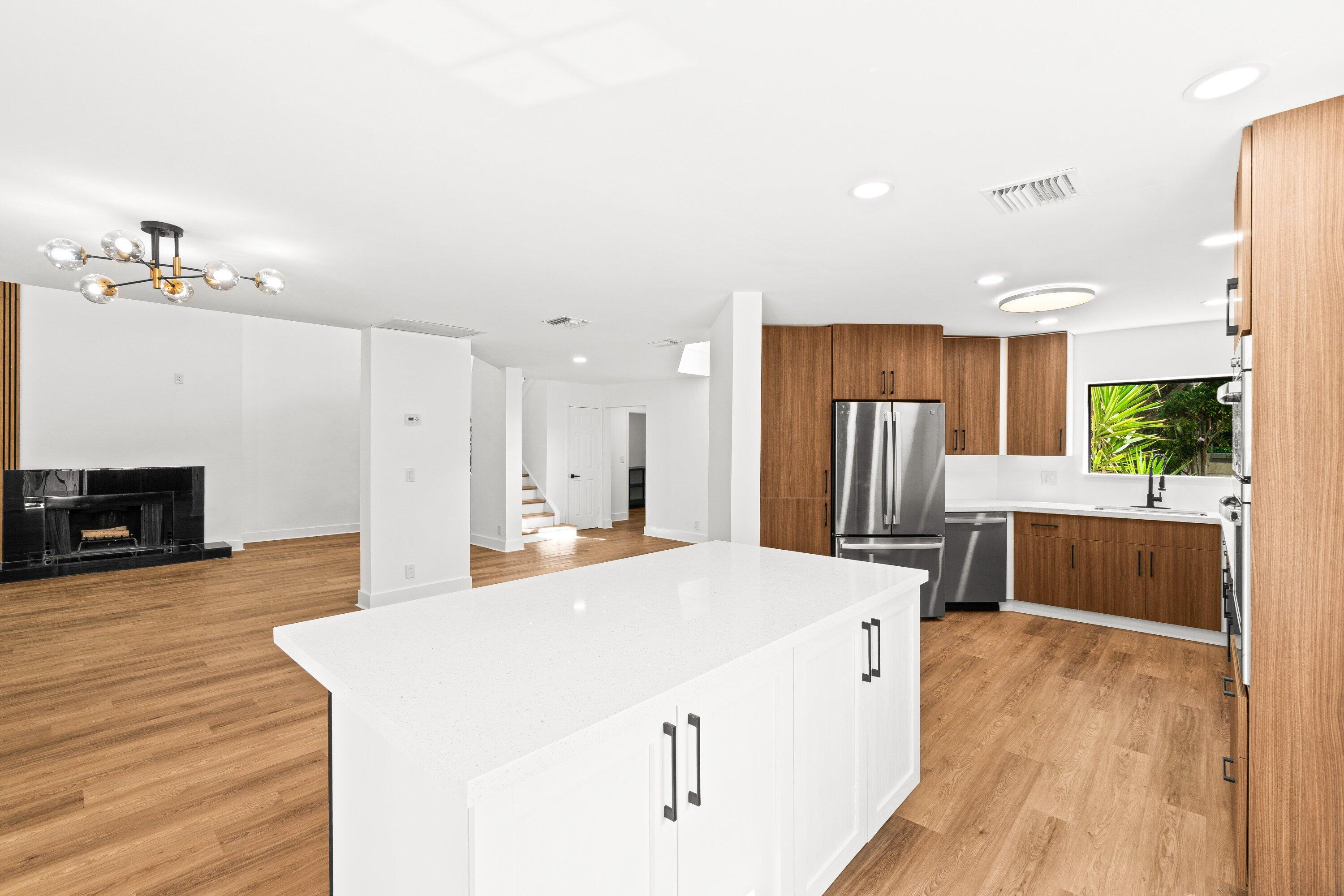 22548 Caravelle Circle, Unit 22548 Boca Raton, FL 33433 - Photo 16 of 40 a large white kitchen with wooden floor and a refrigerator