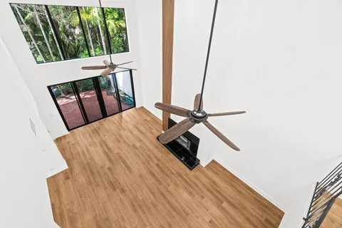 a view of a hallway with wooden floor and staircase