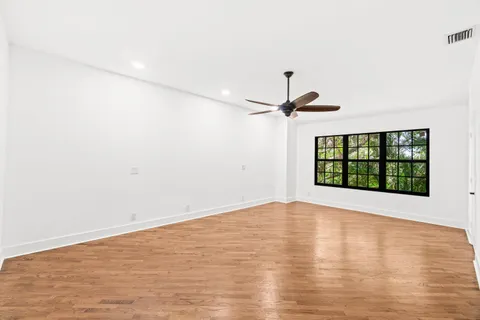 a view of a room with wooden floor and a ceiling fan