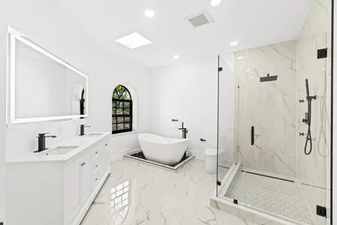 a bathroom with a white tub a sink and mirror