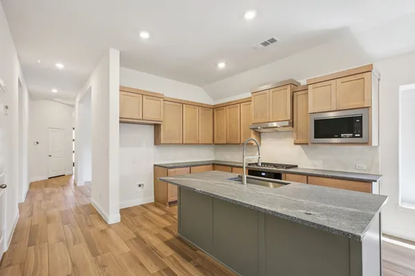 a kitchen with stainless steel appliances granite countertop a sink stove and cabinets