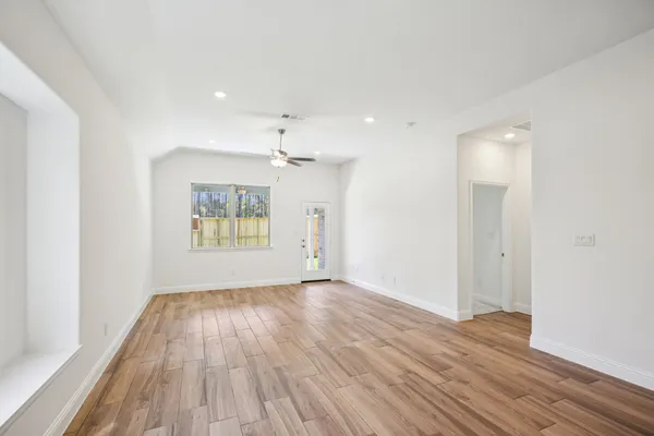 a view of empty room with wooden floor