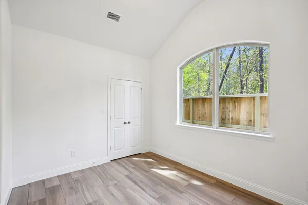 an empty room with closet and windows