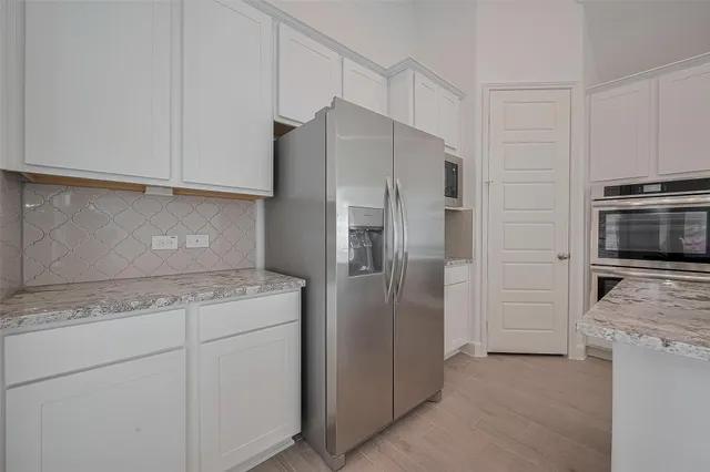 a kitchen with cabinets and stainless steel appliances