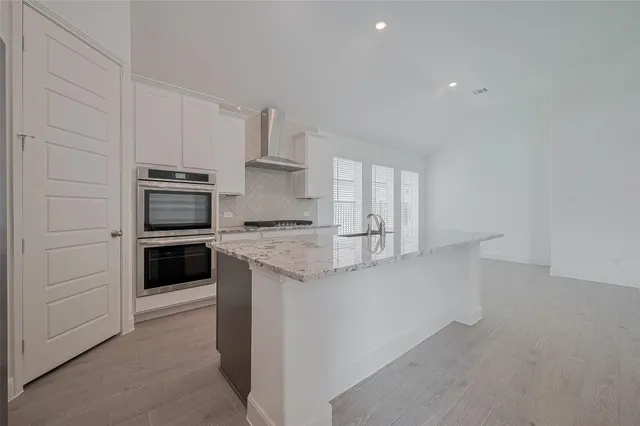 a kitchen with stainless steel appliances granite countertop a stove and a refrigerator