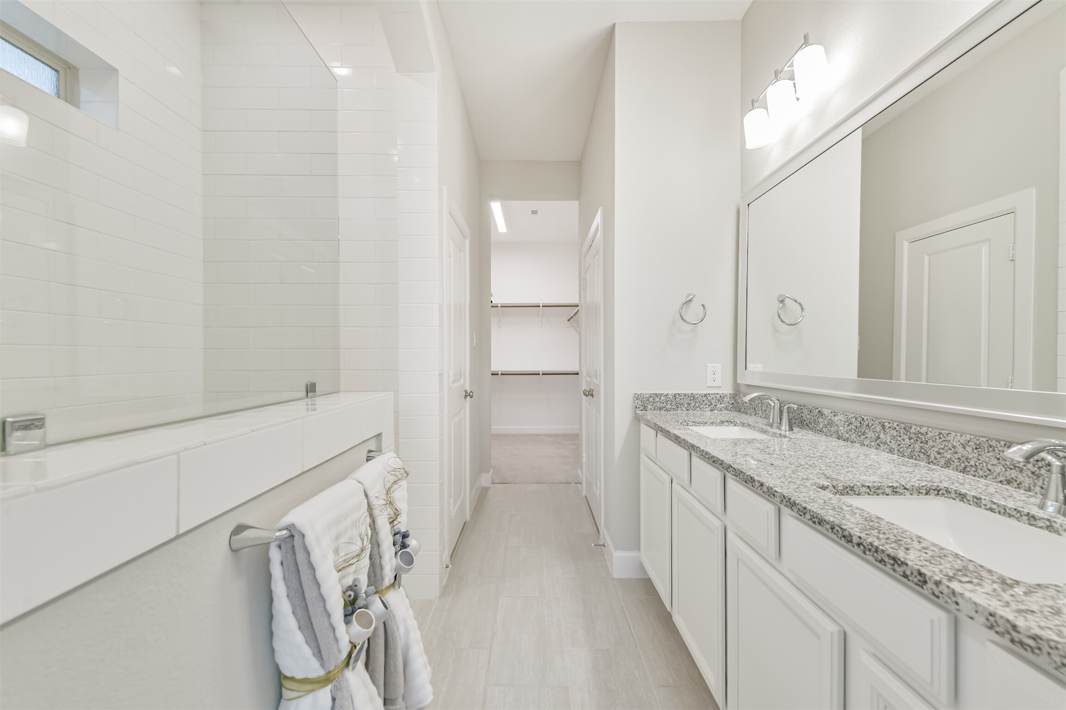 15611 Rising Wren Court Conroe, TX 77302 - Photo 28 of 38 a bathroom with a granite countertop sink a mirror and a bathtub