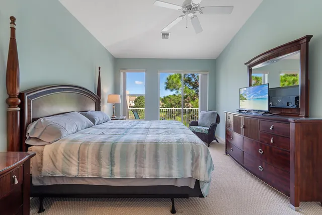a bedroom with a bed and a flat tv screen on dresser