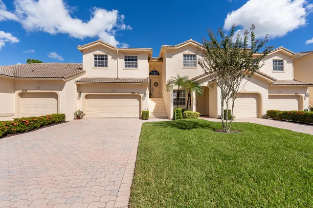 a front view of a house with a garden and plants