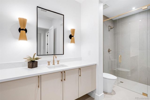 a bathroom with a granite countertop sink a toilet and a mirror