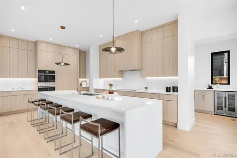 a kitchen with a dining table chairs sink and white cabinets
