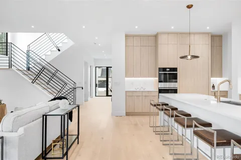 a kitchen with stainless steel appliances kitchen island granite countertop a table chairs refrigerator and microwave