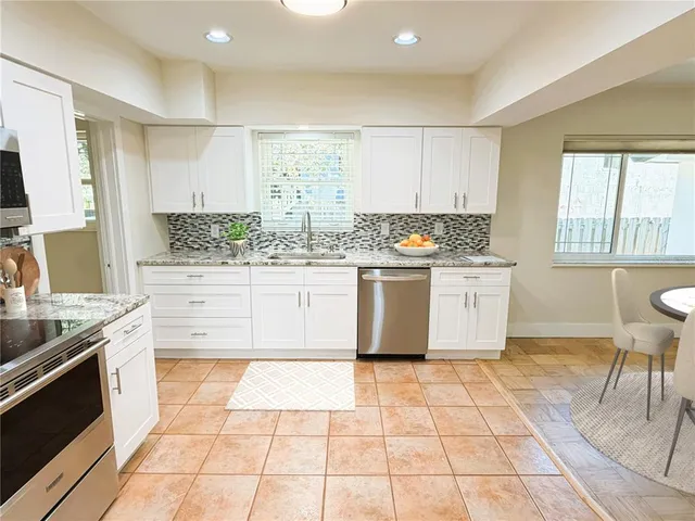 a kitchen with stainless steel appliances a stove sink and cabinets