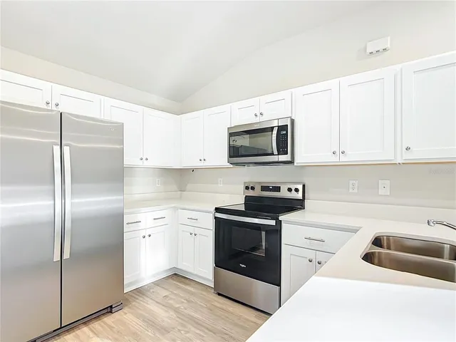 a kitchen with white cabinets and stainless steel appliances