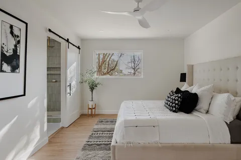 a bedroom with a bed potted plant and a window