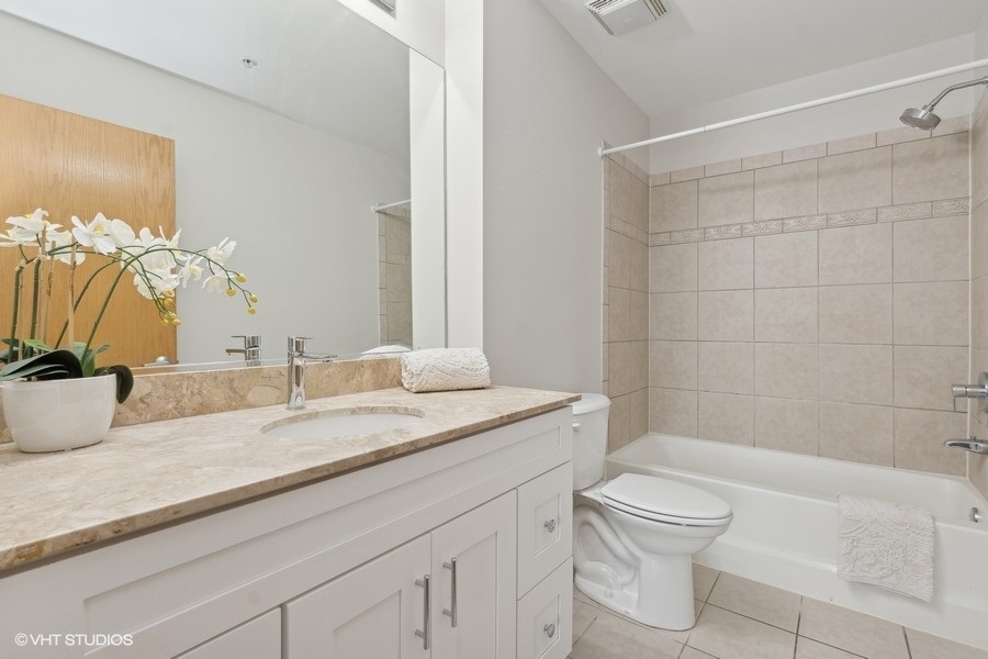 1503 South State Street, Unit 506 Chicago, IL 60605 - Photo 11 of 16 a bathroom with a granite countertop sink mirror vanity and toilet