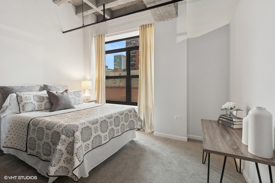 1503 South State Street, Unit 506 Chicago, IL 60605 - Photo 12 of 16 a bedroom with a bed and a table in it