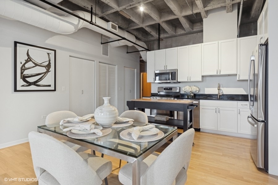 1503 South State Street, Unit 506 Chicago, IL 60605 - Photo 7 of 16 a kitchen with kitchen island granite countertop a sink appliances cabinets and a counter top space