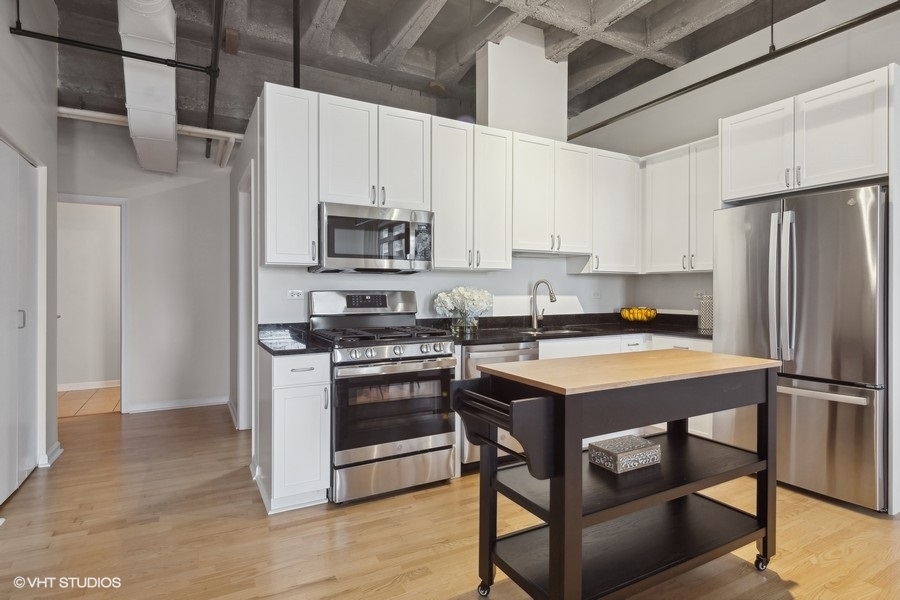 1503 South State Street, Unit 506 Chicago, IL 60605 - Photo 8 of 16 a kitchen with stainless steel appliances a stove a refrigerator a sink and white cabinets