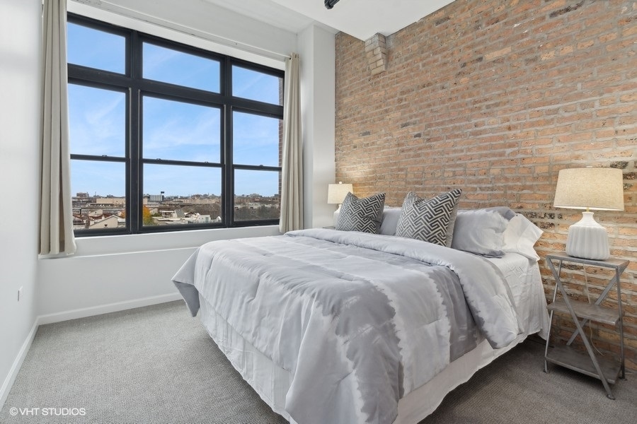 1503 South State Street, Unit 506 Chicago, IL 60605 - Photo 9 of 16 a large bed sitting in a bedroom next to a window