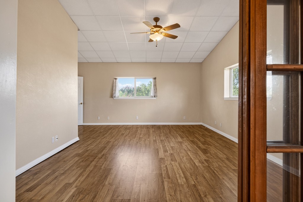 8804 Williamson Road Buda, TX 78610 - Photo 17 of 37 Rich wood-look flooring and structured high ceilings ground this versatile, open living area.
