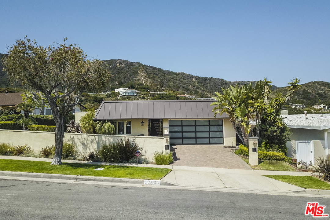 a view of a house with a yard and fence
