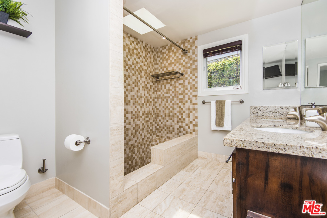 3612 Surfwood Road Malibu, CA 90265 - Photo 12 of 19 a bathroom with a granite countertop sink a toilet and shower